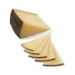 Slices of traditional Spanish Manchego cheese isolated on white background